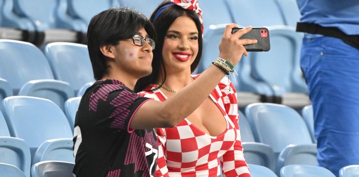 La influencer croata Ivana Knoll posa para las selfies con un seguidor de Japón antes del comienzo del partido de fútbol de octavos de final del Mundial de Catar 2022 entre Japón y Croacia en el estadio Al-Janoub de Al-Wakrah, al sur de Doha.