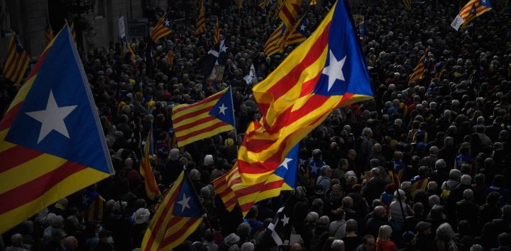 Manifestantes ondean banderas independentistas catalanas "Estelada" durante una concentración contra los cambios en la ley de sedición, convocada por la Asamblea Nacional Catalana (ANC) y otras organizaciones separatistas catalanas en Barcelona.