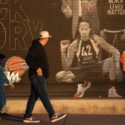 La gente pasa junto a un mural de Brittney Griner fuera del Footprint Center en Phoenix, Arizona. - Griner volvía a casa el jueves tras ser liberada de una prisión rusa en un canje por Viktor Bout, el tristemente célebre traficante de armas conocido como el "Mercader de la Muerte". El Presidente de Estados Unidos, Joe Biden, anunció la liberación de Griner en un discurso a la nación y Moscú confirmó que había sido canjeada en Abu Dhabi por Bout, que cumplía una condena de 25 años de prisión en Estados Unidos. | Foto:Rebecca Noble / AFP