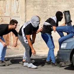 Manifestantes palestinos se cubren durante los enfrentamientos con soldados israelíes tras una protesta contra la expropiación de tierras palestinas por parte de Israel en el pueblo de Kfar Qaddum, en la Cisjordania ocupada, cerca del asentamiento judío de Kedumim. | Foto:Zain Jaafar / AFP
