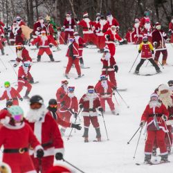Más de 300 esquiadores y snowboarders disfrazados de Papá Noel y otros personajes navideños despegan desde lo alto de la montaña para participar en el evento "Santa Sunday" en Sunday River Resort, en Newry, Maine.  El dinero recaudado se destina a la organización benéfica River Fund Maine. | Foto:Joseph Prezioso / AFP