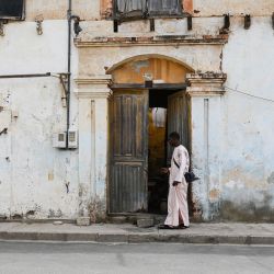 Varias personas caminan por una calle entre edificios en ruinas, en Saint-Louis, un largo periodo de declive político y económico que ha dejado en mal estado muchas obras de arquitectura histórica y otros bienes del patrimonio cultural en Senegal. | Foto:AFP