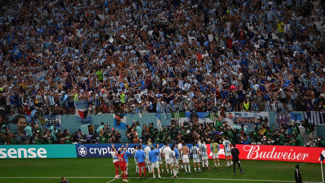 A general view shows Argentina players celebrating with their supporters after they won the Qatar 2022 World Cup quarter-final football match between The Netherlands and Argentina at Lusail Stadium, north of Doha on December 9, 2022. 