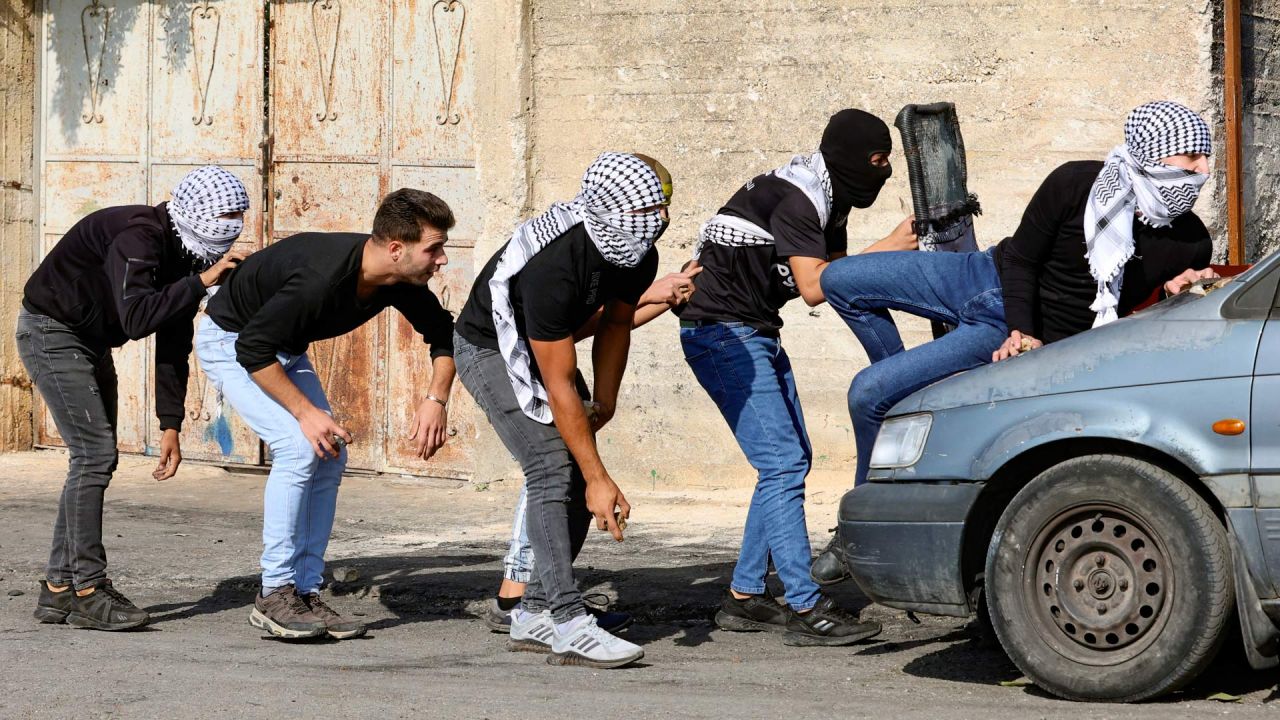 Manifestantes palestinos se cubren durante los enfrentamientos con soldados israelíes tras una protesta contra la expropiación de tierras palestinas por parte de Israel en el pueblo de Kfar Qaddum, en la Cisjordania ocupada, cerca del asentamiento judío de Kedumim. | Foto:Zain Jaafar / AFP