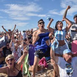 Aficionados de Argentina reaccionan mientras ven la retransmisión en directo del partido de fútbol de semifinales del Mundial de Catar 2022 entre Argentina y Croacia en la playa de Mar del Plata. | Foto:Alfonsina Tain / AFP