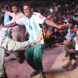 Aficionados paquistaníes bailan mientras ven la transmisión en directo del partido de semifinales de la Copa Mundial de Fútbol Qatar 2022 entre Argentina y Croacia en el barrio de Lyari, en Karachi. | Foto:RIZWAN TABASSUM / AFP