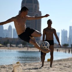Unos hombres juegan al fútbol en la playa de Katara, en Doha, durante el torneo de fútbol de la Copa Mundial Qatar 2022. | Foto:GABRIEL BOUYS / AFP