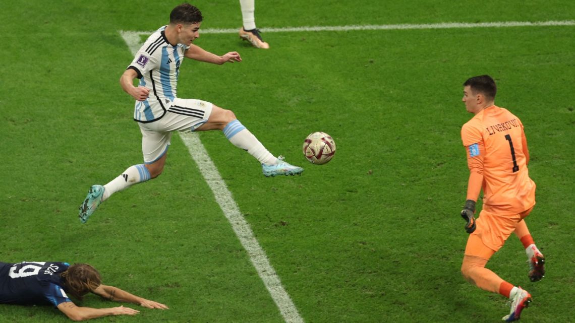 Argentina's forward Julián Álvarez kicks the ball and scores his team's second goal past Croatia's goalkeeper #01 Dominik Livakovic during the Qatar 2022 World Cup football semi-final match between Argentina and Croatia at Lusail Stadium in Lusail, north of Doha on December 13, 2022. 