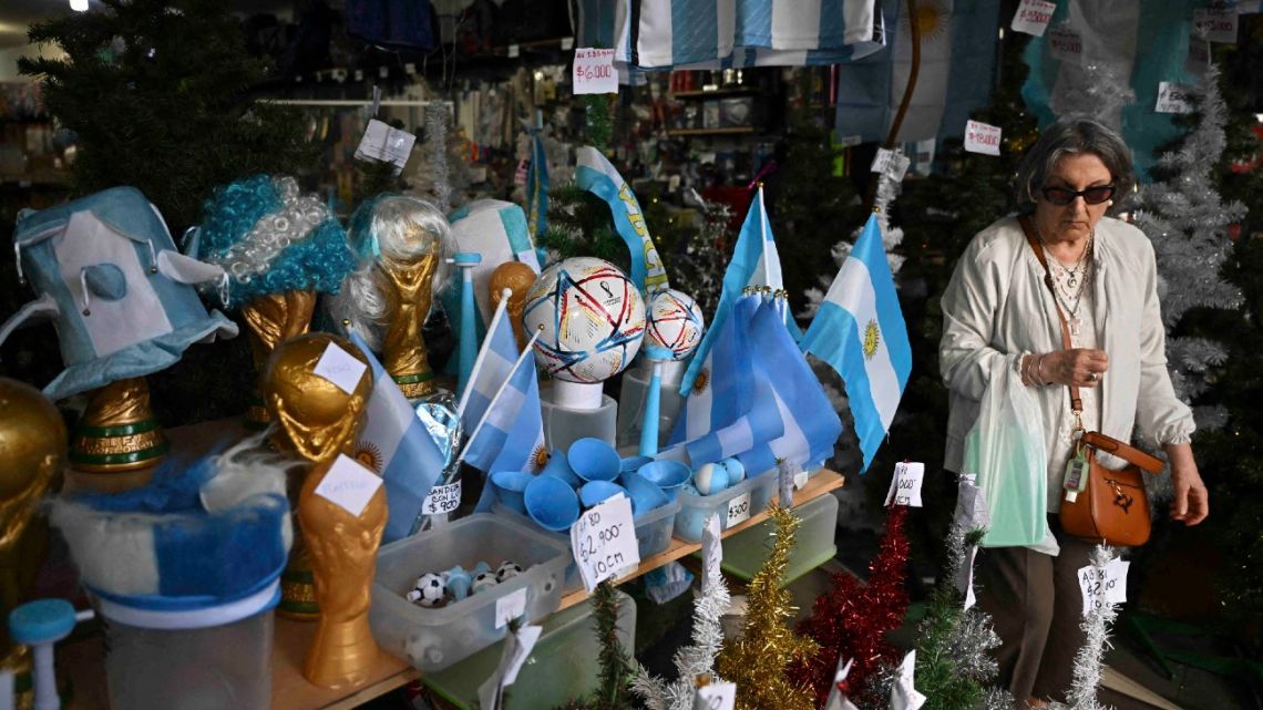 A woman walks inside a store in the eve of the Qatar 2022 World Cup final match between Argentina and France in Buenos Aires, on December 16, 2022. 