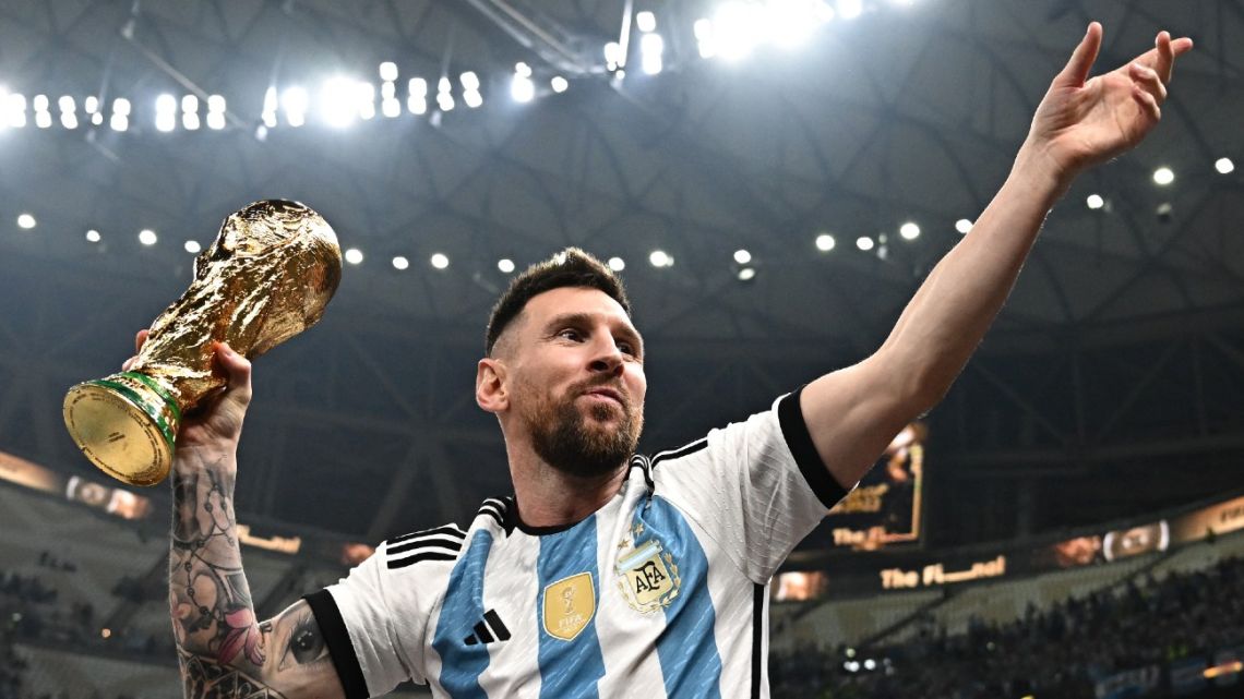 Argentina's captain and forward Lionel Messi poses with the FIFA World Cup Trophy after Argentina won the Qatar 2022 World Cup final.