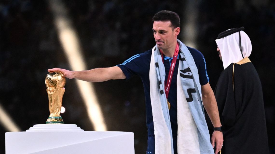 Argentina's coach Lionel Scaloni touches the FIFA World Cup Trophy during the trophy ceremony after Argentina won the Qatar 2022 World Cup final football match between Argentina and France at Lusail Stadium in Lusail, north of Doha on December 18, 2022. 