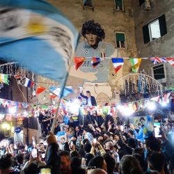 Aficionados de Argentina se reúnen bajo un mural de la difunta leyenda del fútbol argentino Diego Maradona mientras celebran la victoria en el Mundial de Catar 2022 contra Francia en Nápoles, Italia. | Foto:CESARE ABBATE / ANSA / AFP