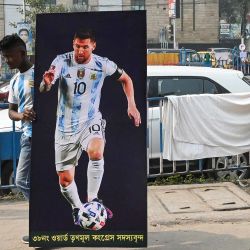 Un aficionado lleva un póster con la imagen del futbolista argentino Lionel Messi mientras anima por su victoria en la final de la Copa Mundial de la FIFA Qatar 2022, en Calcuta, India. | Foto:DIBYANGSHU SARKAR / AFP