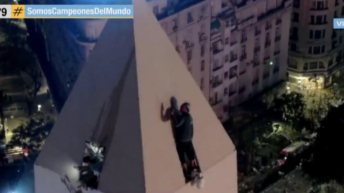 CELEBRATION IN LIMITS: A fan climbs to the top of the obelisk causing tension