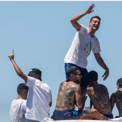 Los jugadores de Argentina sostienen al entrenador Lionel Scaloni mientras el equipo desfila a bordo de un autobús después de ganar el torneo de la Copa Mundial Qatar 2022, en el centro de Buenos Aires. | Foto:TOMAS CUESTA / AFP