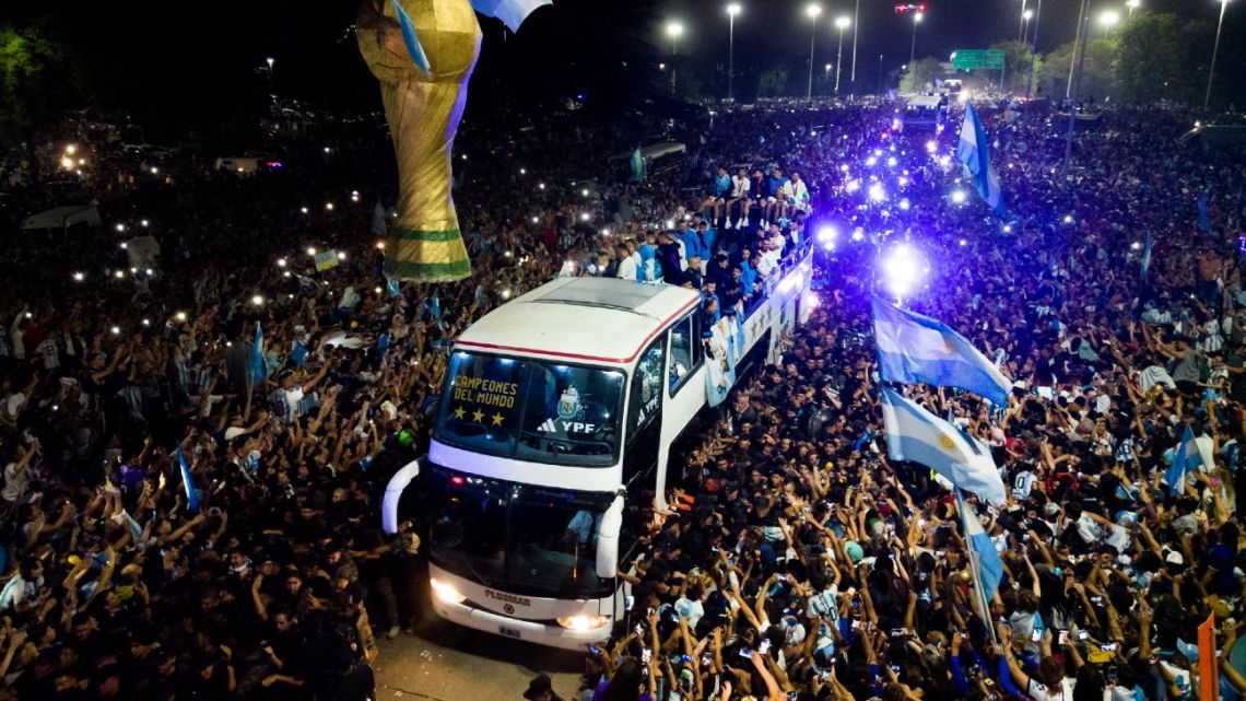This aerial image taken on December 20, 2022, shows Argentina's players celebrating on board a bus with supporters after winning the Qatar 2022 World Cup tournament as they leave Ezeiza International Airport en route to the Argentine Football Association (AFA) training centre in Ezeiza, Buenos Aires province, Argentina. 