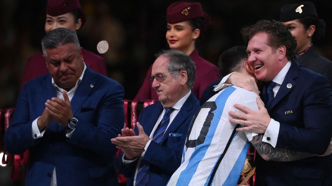 Lionel Messi is greeted by CONMEBOL President Alejandro Domínguez as Argentine Football Federation (AFA) President Claudio Tapia and French Football Federation (FFF) President Noel Le Graet applaud after receiving the Golden Ball award during the Qatar 2022 World Cup trophy ceremony after the football final match between Argentina and France at Lusail Stadium on December 18, 2022. 