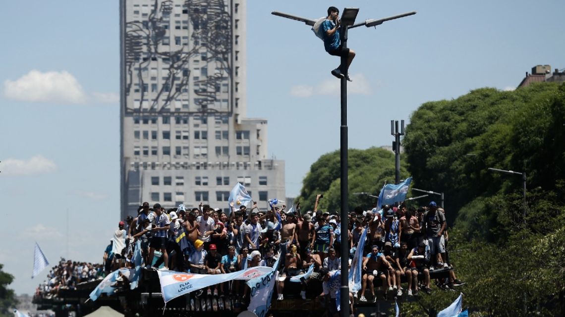 Fans wait for the bus with Argentina's players to pass by the Obelisk to celebrate after winning the Qatar 2022 World Cup tournament in Buenos Aires on December 20, 2022. 