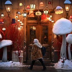 Un peatón pasa junto a la entrada de un restaurante decorado en el centro de Moscú, Rusia. | Foto:YURI KADOBNOV / AFP