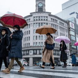 La gente cruza la calle en un día frío y lluvioso en la zona de Ginza, en Tokio, Japón. | Foto:Richard A. Brooks / AFP