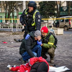 Un socorrista y un policía ucraniano consuelan a un hombre mientras reacciona junto al cuerpo de una mujer muerta tras un bombardeo ruso a la ciudad ucraniana de Kherson, donde murieron cinco personas y 20 resultaron heridas. | Foto:DIMITAR DILKOFF / AFP