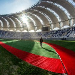Un hombre camina cerca del terreno de juego del Nuevo Estadio Olímpico Minaa, construido para albergar a 30.000 espectadores, en la ciudad de Basora, en el sur de Irak, antes de su inauguración en un partido amistoso de exhibición entre el club iraquí al-Minaa y el Kuwait SC. | Foto:Hussein Faleh / AFP