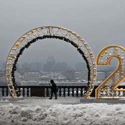 Un peatón camina junto a los números del Año Nuevo 2023 en el punto de observación de Vorobyovy Hills en Moscú, Rusia. | Foto:ALEXANDER NEMENOV / AFP