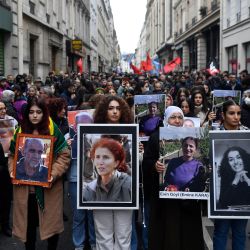 Manifestantes sostienen los retratos de las víctimas del tiroteo de la calle Enghien en París en diciembre de 2022, y los de los asesinatos de la calle La Fayette en 2013, mientras participan en una marcha para rendirles homenaje y en solidaridad con la comunidad kurda en París. | Foto:JULIEN DE ROSA / AFP