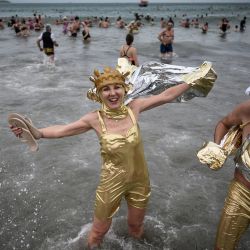 Un bañista posa mientras cientos de personas participan en un tradicional baño de mar "disfrazado" al oeste de Francia. | Foto:LOIC VENANCE / AFP