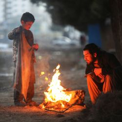 Afganos se calientan junto a una hoguera en un día de invierno en Kabul. | Foto:AFP