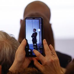 El presidente francés, Emmanuel Macron, aparece en la pantalla de un teléfono móvil durante la presentación de la tarta de Reyes con miembros de la Federación Francesa de Panadería y Pastelería en el Palacio del Elíseo, en París. | Foto:YOAN VALAT / POOL / AFP