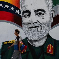 Un hombre camina junto a un mural pintado por el artista venezolano Nelson Santana que representa al general iraní asesinado Qasem Soleimani en el barrio 23 de Enero en Caracas, Venezuela. | Foto:Federico Parra / AFP
