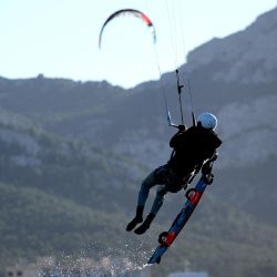 Un kitesurfista salta en el aire mientras soplan fuertes vientos en Marsella, en el sur de Francia. Foto de Nicolas TUCAT / AFP | Foto:AFP