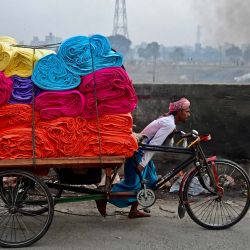 Un trabajador tira de su rickshaw cargado con fardos de tela en Dhaka. Foto de Munir uz ZAMAN / AFP | Foto:AFP