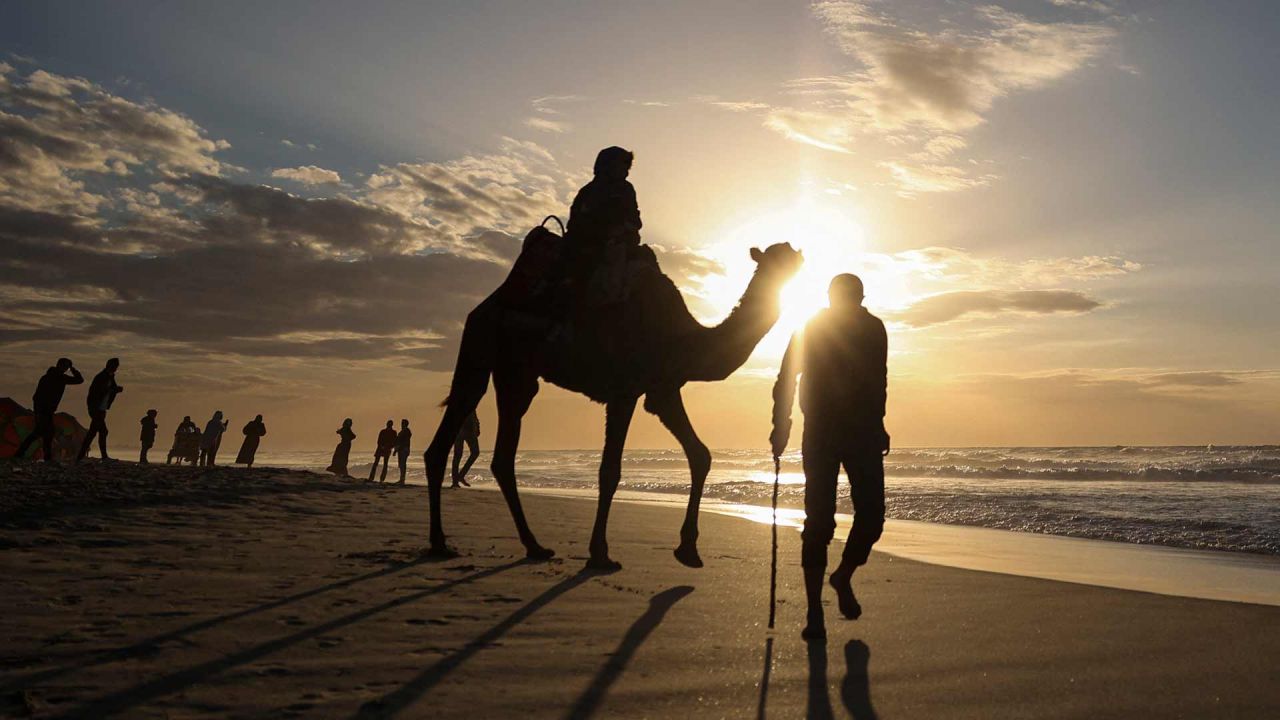 Un palestino monta un camello por la playa mientras se pone el sol en la ciudad de Gaza. Foto de MOHAMMED ABED / AFP | Foto:AFP