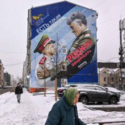 Un peatón pasa junto a un mural que representa a un general ruso y un cadete con el lema "Existe tal profesión: defender la patria" en Moscú. Foto de Yuri KADOBNOV / AFP | Foto:AFP