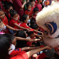 Los niños dan dinero a los artistas de la danza del león en una escuela como parte de las festividades para dar la bienvenida al próximo Año Nuevo Lunar del Conejo en Solo, Java Central. Foto de Adek BERRY / AFP | Foto:AFP