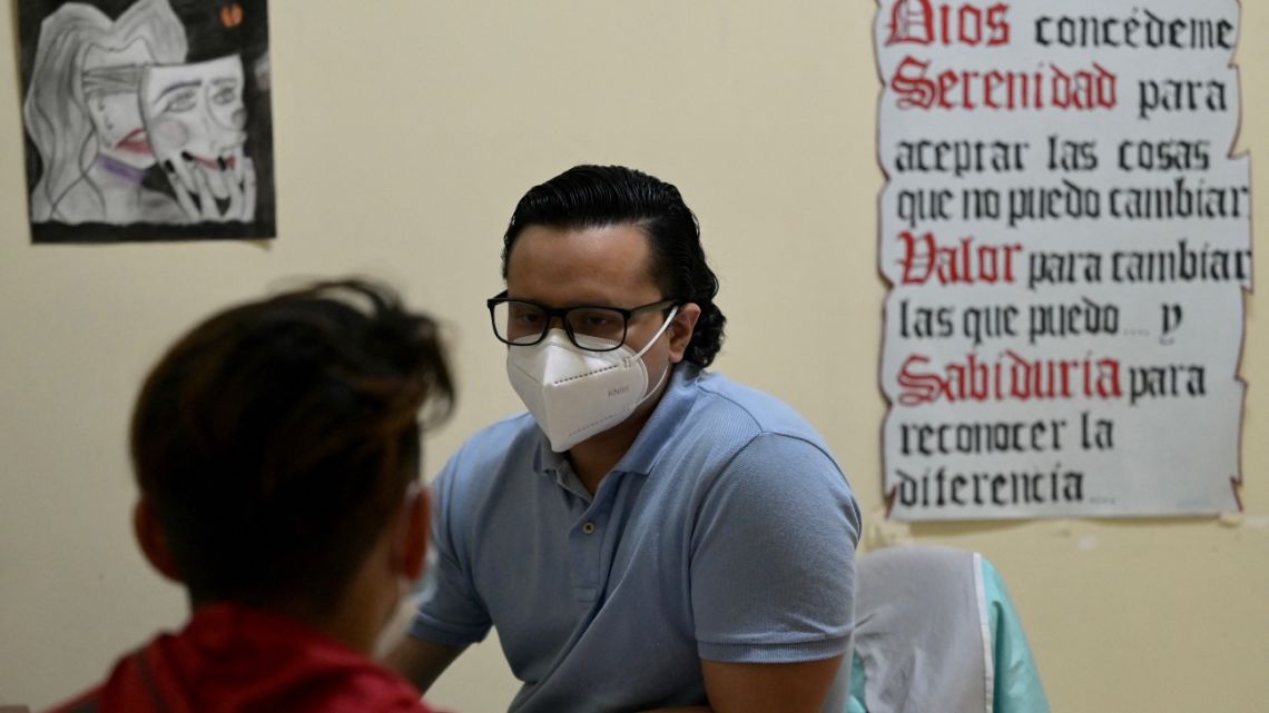 Psychologist Angel Roman speaks to a patient with addiction problems in one of the consulting rooms of the municipal program "For a future without drugs" at the Bicentenario hospital in Guayaquil, Ecuador on January 6, 2023.