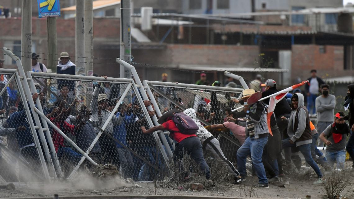 Demonstrators pull down a fence while trying to enter the Rodriguez Ballon airport in Arequipa, Peru, during a protest against the government of President Dina Boluarte and to demand her resignation, on January 19, 2023.