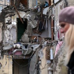 Una mujer pasa por delante de un edificio residencial en la ciudad ucraniana de Dnipro, destruido como consecuencia de un ataque con misiles. | Foto:Anatolii Stepanov / AFP