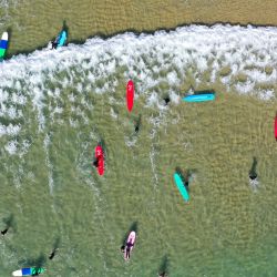 Vista aérea de turistas surfeando en la Bahía Riyue, en Wanning, en la provincia de Hainan, en el sur de China. El surf se ha convertido en un símbolo de Wanning gracias a sus singulares ventajas geográficas y climáticas. | Foto:Xinhua/Guo Cheng