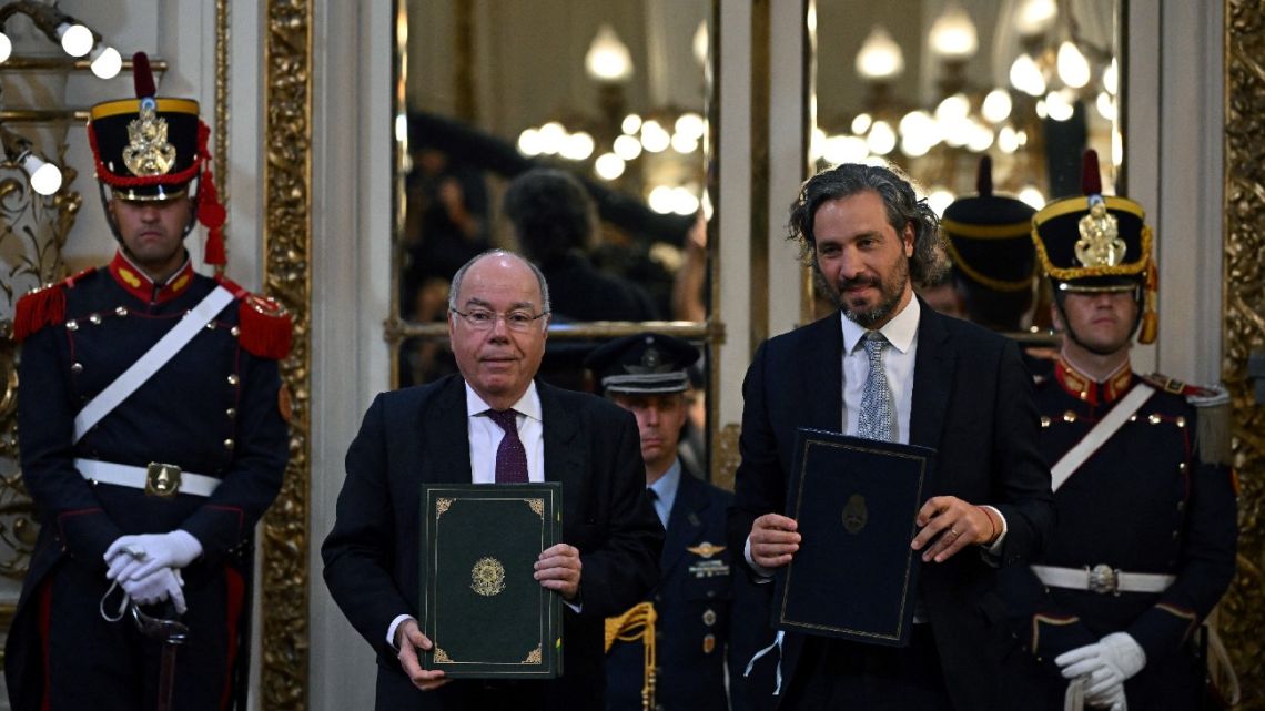 Argentina's Foreign Minister Santiago Cafiero and his Brazilian counterpart Mauro Vieira exchange folders after signing an agreement in Buenos Aires, on January 23, 2023.