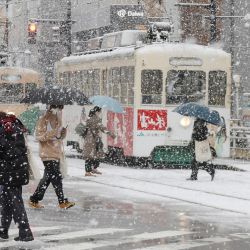 Varias personas cruzan la calle mientras nieva en la ciudad de Toyama, prefectura de Toyama, en la costa centro-occidental de Japón, mientras algunas partes del país se preparan para una fuerte tormenta invernal. | Foto:JIJI PRESS / AFP