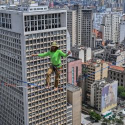 El highliner brasileño Rafael Bridi actúa sobre una slackline de 114 metros de altura y 510 metros de longitud, cruzando todo el Vale do Anhangabau, en el marco del 469 aniversario de la ciudad de Sao Paulo, Brasil. | Foto:NELSON ALMEIDA / AFP
