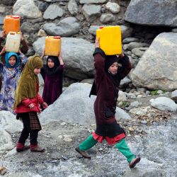 En esta fotografía niñas afganas transportan bidones de agua potable después de llenarlos de un arroyo en el distrito de Dara-i-Nur de la provincia de Nangarhar. | Foto:Shafiullah KAakar / AFP