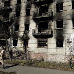 Una mujer pasa junto a un bloque de apartamentos destruido en la ciudad de Severodonetsk, controlada por Rusia, en la región oriental de Lugansk, Ucrania. | Foto:STRINGER / AFP