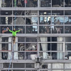 El highliner brasileño Rafael Bridi actúa sobre una slackline de 114 metros de altura y 510 metros de longitud, cruzando todo el Vale do Anhangabau, en el marco del 469 aniversario de la ciudad de Sao Paulo, Brasil. | Foto:NELSON ALMEIDA / AFP