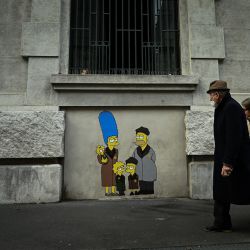 Un grupo de personas pasa junto a un mural del artista callejero italiano AleXsandro Palombo titulado "Track 21 Los Simpson deportados a Auschwitz" cerca de la estación central de tren de Milán, con motivo del próximo Día Internacional de Conmemoración del Holocausto. | Foto:PIERO CRUCIATTI / AFP