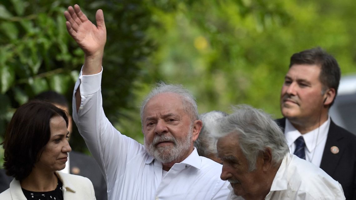 Brazilian President Luiz Inácio Lula da Silva waves next to Uruguayan former president José Mujica at the latter's farm in Rincon del Cerro, Montevideo, on January 25, 2023, during his visit to Uruguay. 