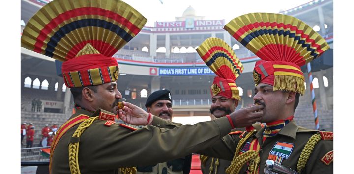 Soldados indios de la Fuerza de Seguridad Fronteriza posan mientras se ofrecen caramelos unos a otros durante las celebraciones para conmemorar el Día de la República del país en el puesto fronterizo de Wagah entre India y Pakistán, a unos 35 km de Amritsar.